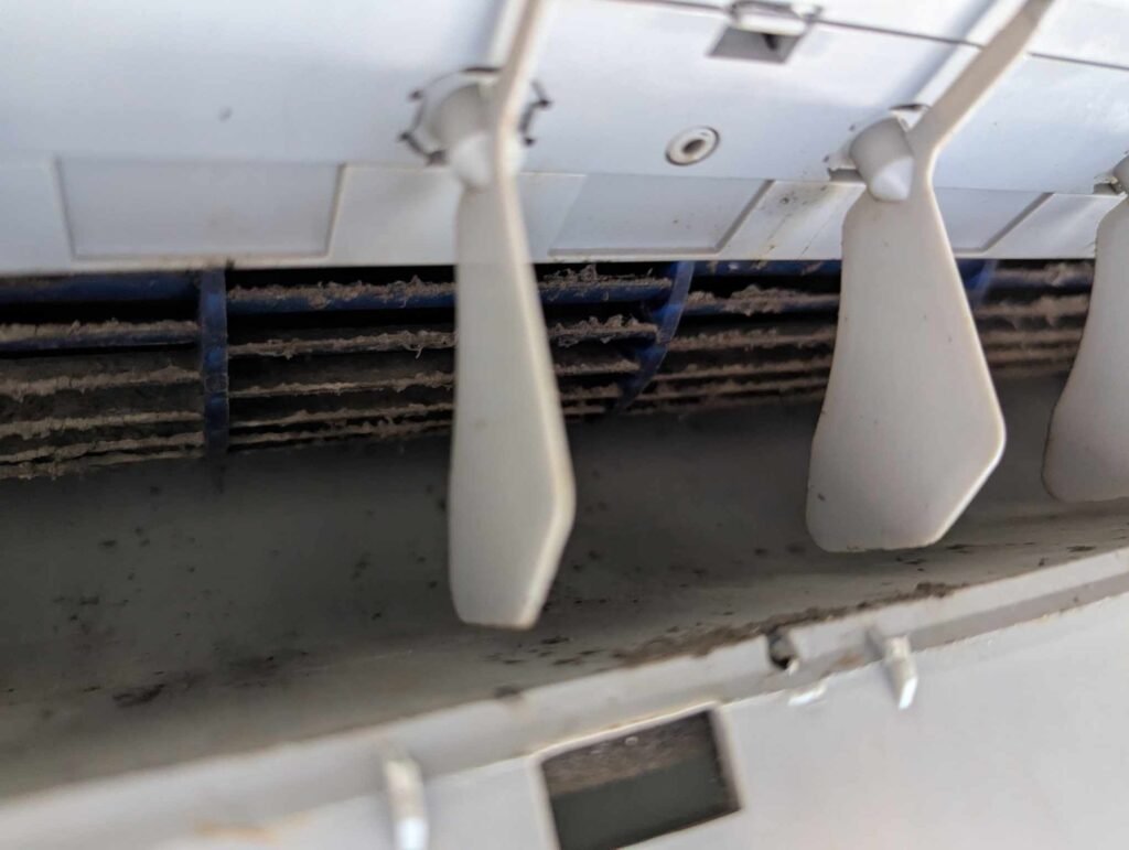 Vue rapprochée du ventilateur de climatiseur avec accumulation de saleté